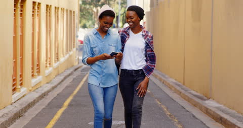 Twin Sisters Strolling and Smiling in Urban Alleyway