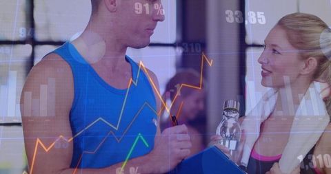 Trainer discussing fitness goals with client in gym environment