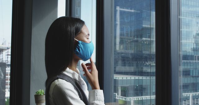 Woman in Blue Face Mask Looking Out City Window During Daytime - Download Free Stock Images Pikwizard.com