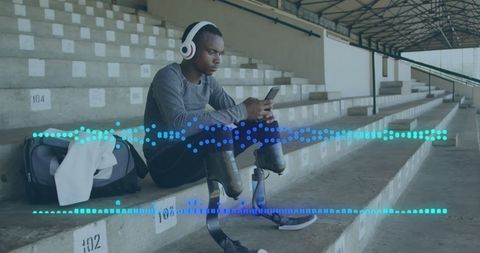 Determined Athlete with Prosthetics Listening to Music at Stadium