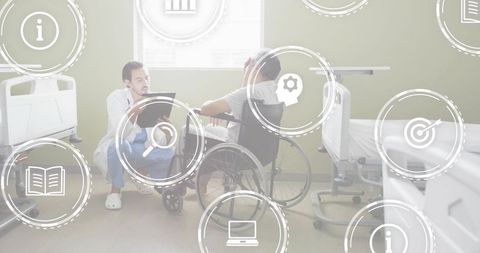 Crouching clinician reviewing tablet with wheelchair patient in hospital ward showing care icons