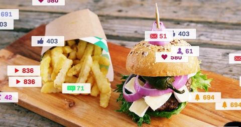 Gourmet sesame burger and crinkle fries on rustic board with social media icons