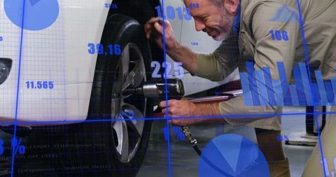 Kneeling Mechanic Tightening Car Wheel with Impact Wrench and Data Analytics Overlay