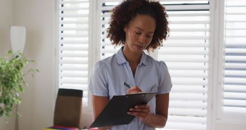 Female Physiotherapist Writing on Clipboard in Health Consultation