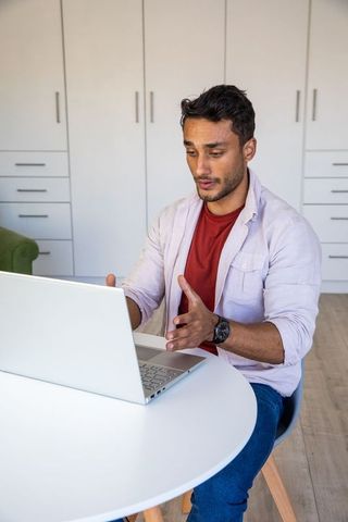 Man engaging in online meeting in home workspace environment