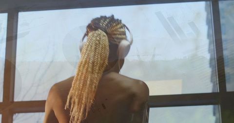 Active Afro-American Woman with Headphones Overlaid with Graphs