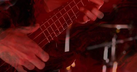 Dynamic Motion of Bass Guitarist in Vivid Red Light