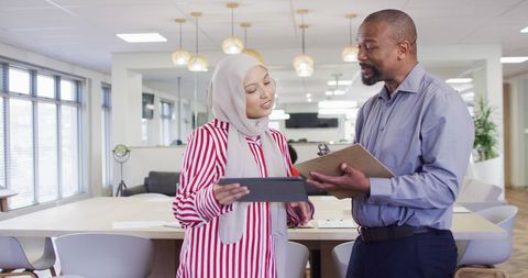 Diverse professionals collaborating with technology in office