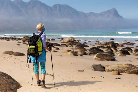 Female Hiker Trekking Along Scenic Beach with Trekking Poles