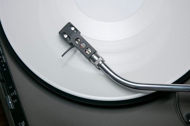 Close-up shot of vintage turntable playing white vinyl record provides a nostalgic and classy aesthetic. Ideal for use in music-themed blogs, retro music promotions, audio equipment marketing materials, or design elements for vintage-inspired projects.