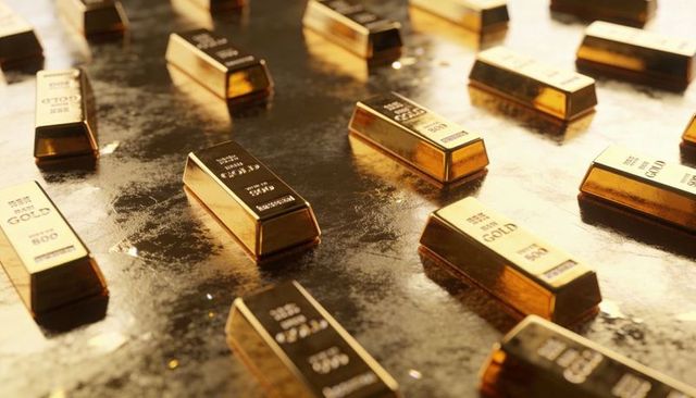 Glinting stacked gold bars resting on reflective metal surface showing bullion markings