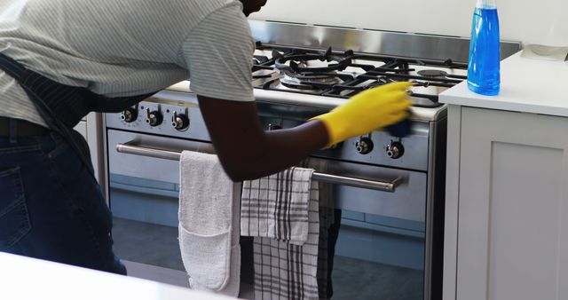 Person Cleaning Kitchen Stove with Yellow Gloves - Download Free Stock Images Pikwizard.com