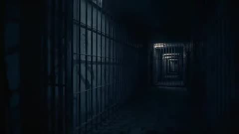 Tracking shot gliding through dim prison cell block with metal bars and shadowy gates