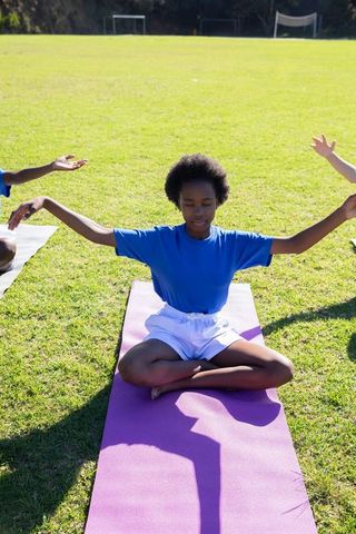 Teen Meditating Outdoors on Mat Embraces Serenity in Nature