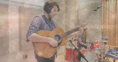 Musician Strumming Acoustic Guitar in Professional Recording Studio
