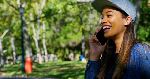 Young Woman Talking on Smartphone in Sunny Park - Download Free Stock Images Pikwizard.com