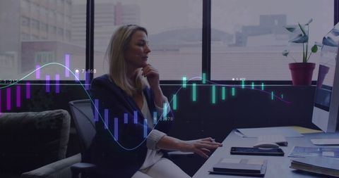 Businesswoman Analyzing Financial Data on Computer at Office Desk