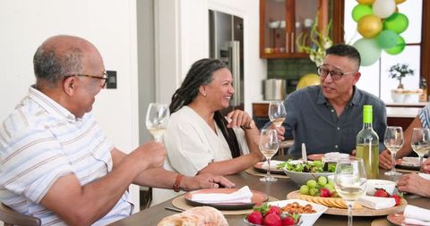 Senior Friends Enjoying Celebration Over Dinner and Wine