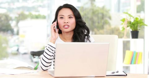 Confident Woman Multitasking with Laptop and Smartphone in Bright Office - Download Free Stock Images Pikwizard.com