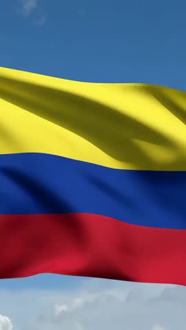 Waving Colombian flag in vertical video under bright blue sky with flowing fabric folds