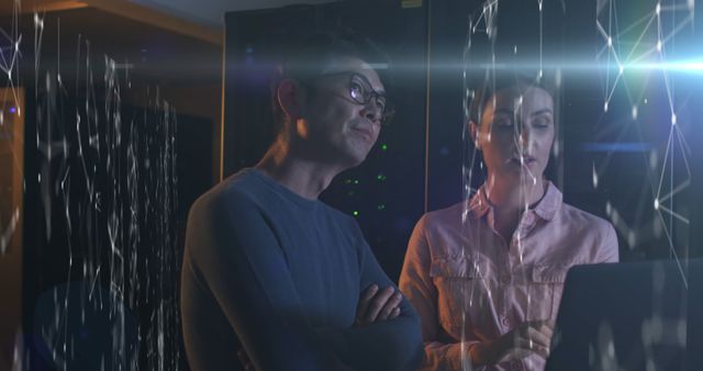 Image of data over diverse male and female it engineers checking computer servers. digital interface, cloud computing concept and technology concept digitally generated image.