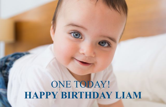 This close-up shows a baby smiling joyfully while lying on a bed, making it perfect for celebrating a first birthday. It can be used for family cards, social media posts, advertisements for baby products, or birthday party invitations.