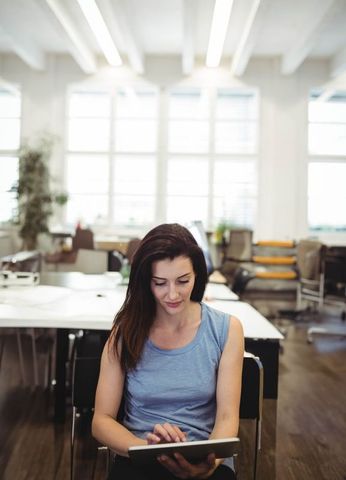 Focused woman utilizing tablet in modern coworking space