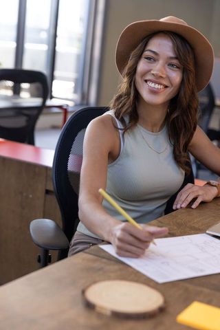 Smiling designer sketching at office workspace