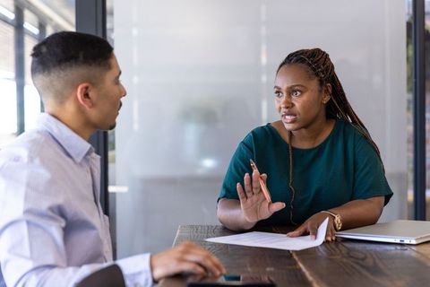 Coworkers Collaborating on Business Report at Office Table