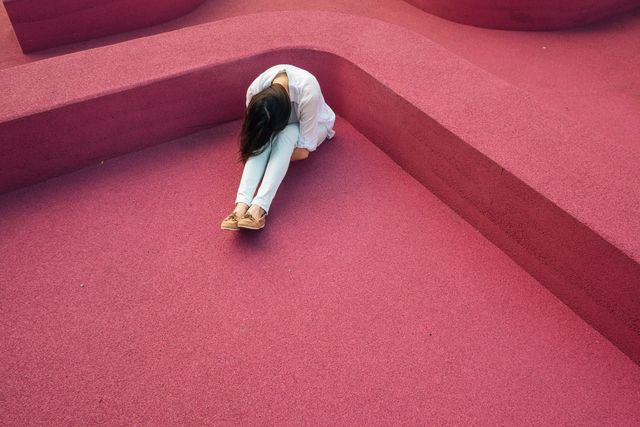 Woman Sitting Alone on Pink Geometric Surface Examining Emotions - Download Free Stock Photos Pikwizard.com