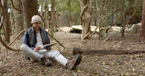 Man reading book in serene woodland setting for tranquil nature retreat