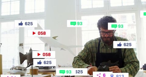 Artisan carving fish sculpture surrounded by social media icons