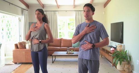 Couple practicing guided breathwork at home wearing smartwatches with breathing rings