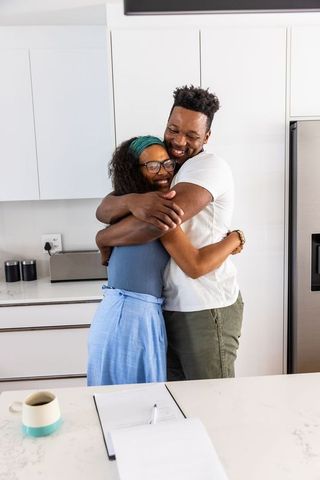 Couple hugging in modern kitchen sharing warm embrace and joyful connection