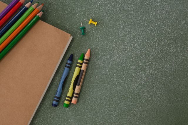 Color pencils, crayons, push pins and book on chalkboard - Download Free Stock Photos Pikwizard.com