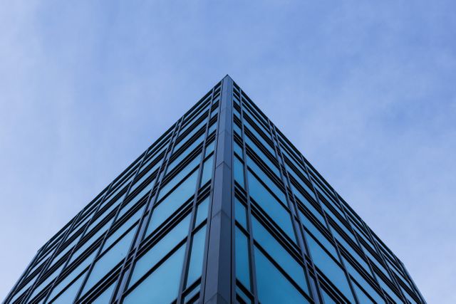Low Angle View of Modern Office Building Against Blue Sky - Download Free Stock Photos Pikwizard.com