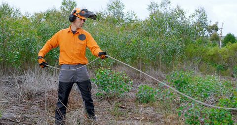Caucasian Worker in Protective Gear Using Outdoor Hose - Download Free Stock Images Pikwizard.com