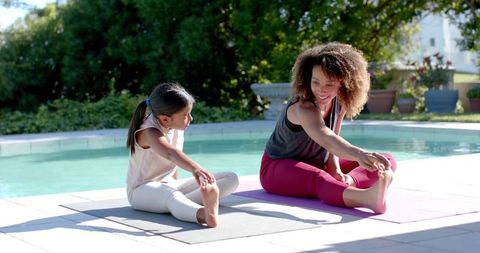 Mother and Daughter Enjoy Outdoor Yoga by Pool
