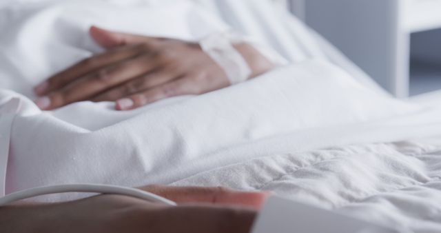 White hospital bed with patient hand visible and IV line - Download Free Stock Images Pikwizard.com