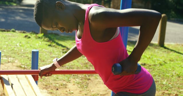 Young Woman in Pink Top Exercising with Dumbbells Outdoors - Download Free Stock Images Pikwizard.com