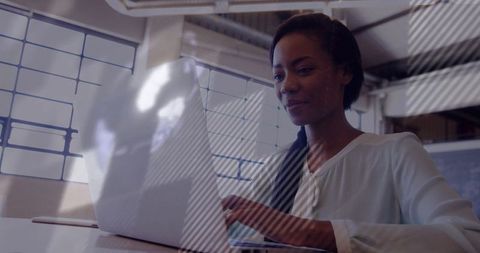 Focused Woman Typing on Laptop in Modern Office