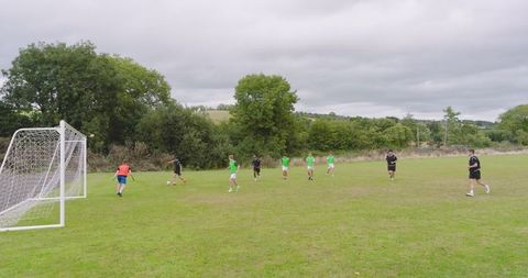 Teenage Boys Playing Soccer Game on Green Sports Field