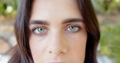 Close-Up of Woman with Green Eyes in Garden Setting