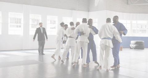 Hugging martial artists celebrating teamwork and camaraderie after jiu-jitsu training