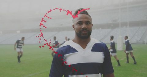 Standing rugby player wearing navy and white striped jersey with red heart overlay