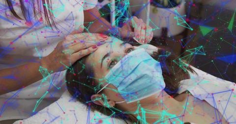 Masked client receiving microblading and eyebrow shaping cosmetic treatment in clinic