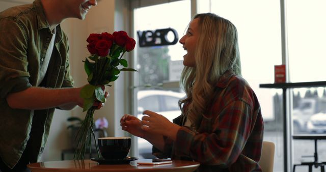 Man surprising woman with roses at cozy cafe - Download Free Stock Images Pikwizard.com