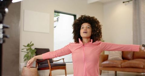 African american woman stretching in living room during morning home workout