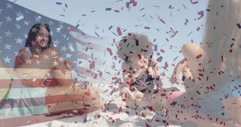 Joyful friends on beach festival with confetti and flags