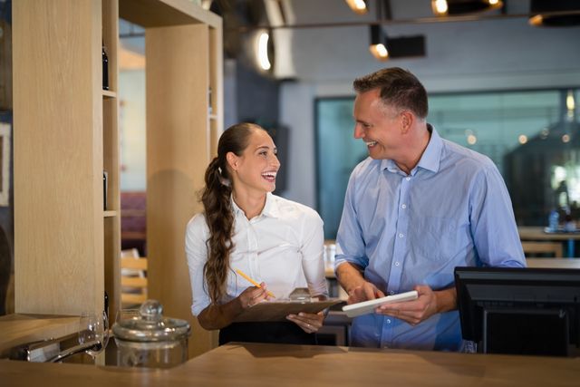 Smiling Manager and Bartender Interacting in Modern Bar - Download Free Stock Images Pikwizard.com